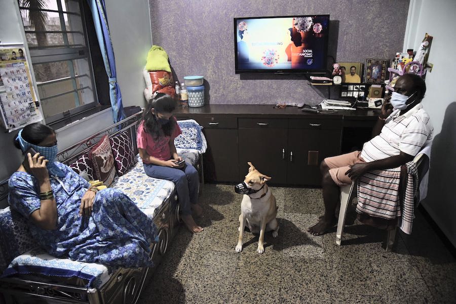 Mumbai: Family members wearing masks sit in a room during the nationwide lockdown imposed in a bid to contain the spread of coronavirus pandemic, at Borivali in Mumbai. (PTI Photo)