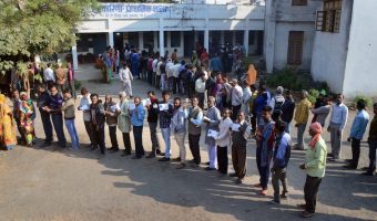 People wait with their identity cards to cast their votes for the Assembly elections, in Jabalpur, Madhya Pradesh, Wednesday, Nov 28, 2018.